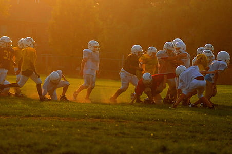 football players playing in green grass field thumbnail
