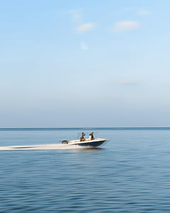 group of people on speedboat at body of water under blue sky thumbnail