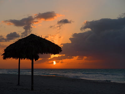hay shade on seashore during orange sunset thumbnail