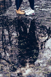 reflection photography of two-person standing near tree thumbnail
