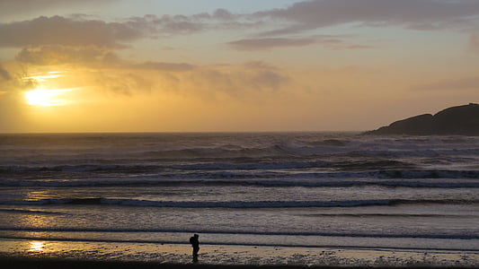 silhouette of man standing beside seashore thumbnail