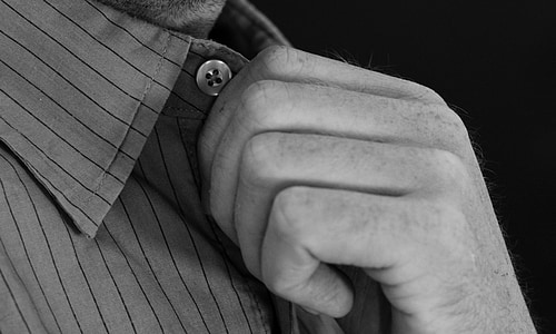 grayscale photo of person holding button-up collared shirt thumbnail