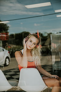 woman wearing headphones sitting on chair inside building during daytime thumbnail