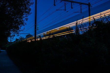 time-lapsed photography of yellow train light during night thumbnail