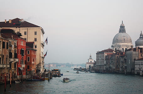 White Motor Boat on Ocean Beside Concrete Buildings thumbnail