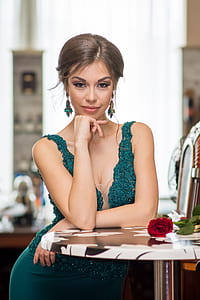 smiling woman wearing green glitter sleeveless dress at the table thumbnail