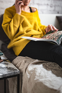 Young woman reading a magazine in bed thumbnail