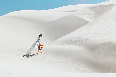 woman walking on desert during daytime thumbnail