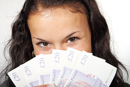 woman holding 20 English pound banknotes thumbnail