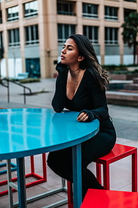 woman sitting in front of blue patio table thumbnail