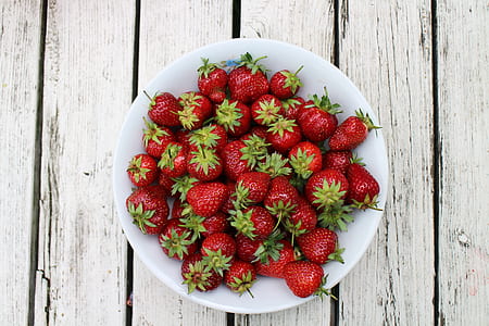 red strawberries in white ceramic bowl thumbnail