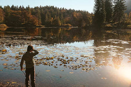 man standing on body of water during daytime thumbnail