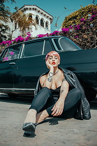 woman sitting near black sedan thumbnail