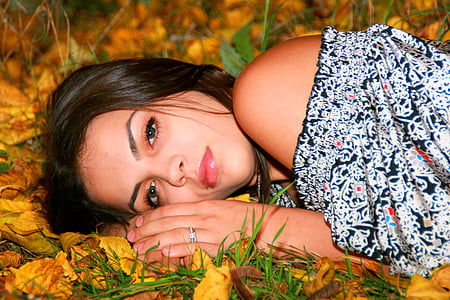 woman in off-shoulder top lying on dried leaves thumbnail