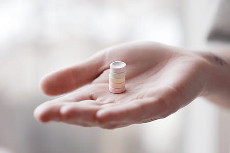 stack of medicine tablets on person's palm thumbnail