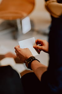 Women folding sheet of paper while making origami thumbnail