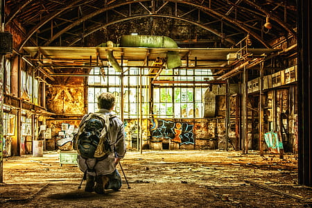 man kneeling inside a room full of graffiti on walls thumbnail
