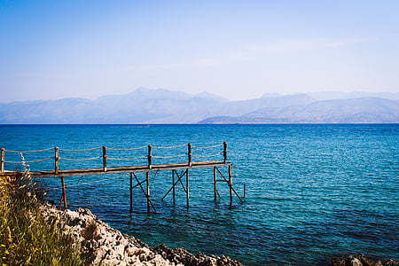 brown wooden dock on blue ocean during daytime thumbnail