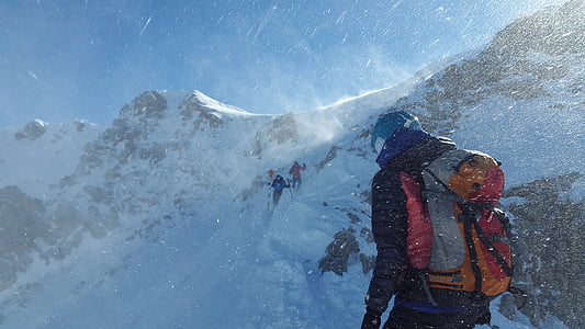 people climbing on snow capped mountain during daytime thumbnail