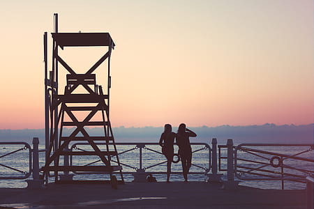 silhouette of women standing on ship under gray sky thumbnail