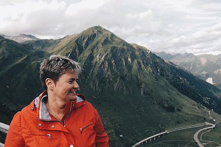 Person Wearing Windbreaker Jacket Standing Near on Mountain Range thumbnail