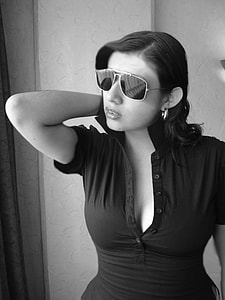 grayscale photo of woman wearing black button-up blouse and sunglasses thumbnail