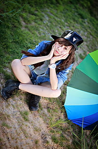 woman sitting on green grass near umbrella thumbnail