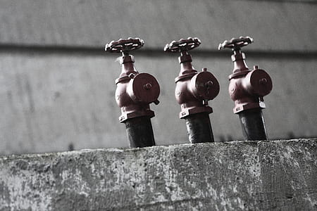 three brown metal valves on gray concrete floor thumbnail