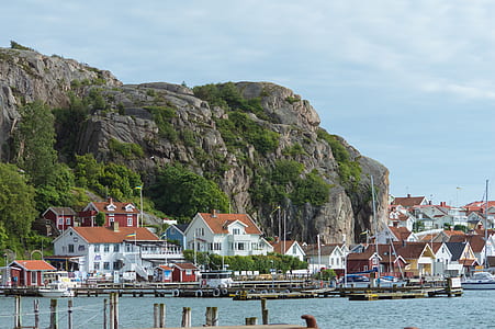 mountain beside houses near body of water thumbnail