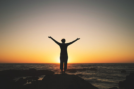Silhouette of a person enjoying the sunset on the coast thumbnail