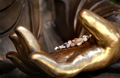 assorted stones on hand of statue thumbnail
