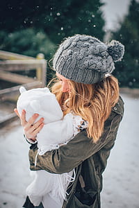 woman in gray holding baby in white footsie during daytime thumbnail