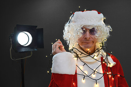 man wearing Santa Claus with string lights near black studio lamp thumbnail