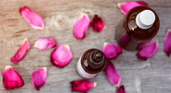 two amber glasses with pink rose petals thumbnail