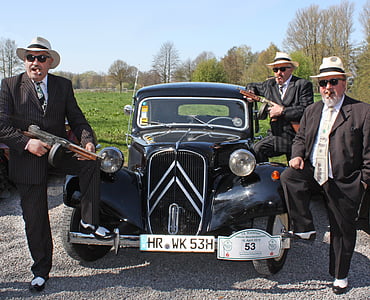 three men standing beside black vehicle thumbnail