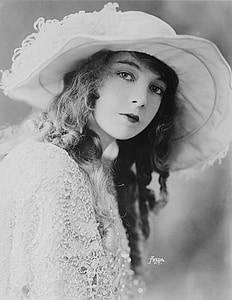 grayscale photography of woman in lace dress and hat thumbnail