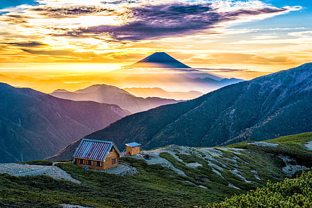 brown house on mountain under white and blue sky thumbnail
