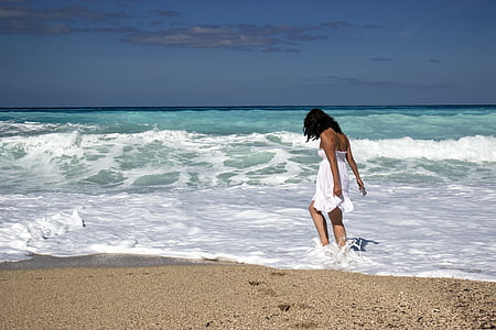 woman standing at beach during daytime thumbnail