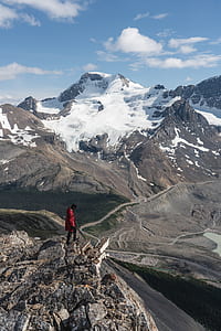 man standing on mountain peak taken during daytime thumbnail