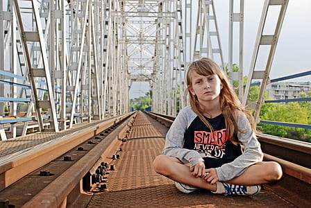 girl sitting on brown metal surface thumbnail