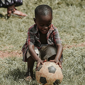boy holding white and black soccer ball thumbnail