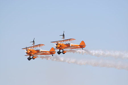 two orange airplanes on sky thumbnail