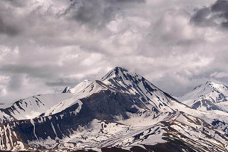 snow covered mountains under cloudy sky thumbnail