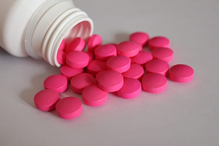 round pink medication pills on white surface thumbnail
