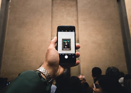 person holding black smartphone taking photo of painting thumbnail