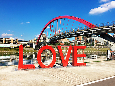 red love freestanding letters near bridge during daytime thumbnail
