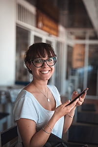 woman smiling while holding phone thumbnail