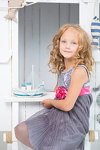 Girl in Grey Sequin Pleated Mini Dress Sitting Near White thumbnail