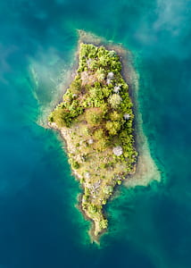 green island in the middle of body of water thumbnail