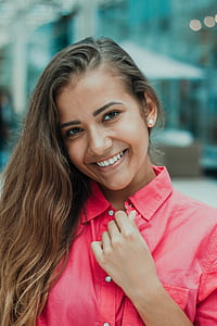 woman holding her pink button-up collared top thumbnail